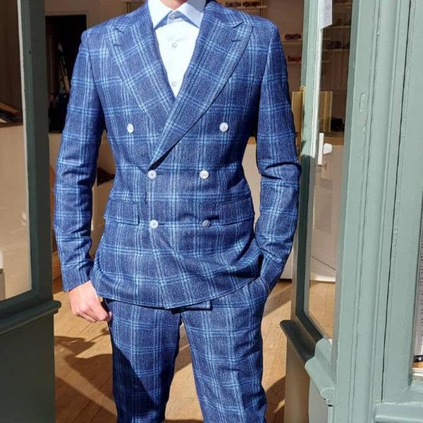 Costume croisé à carreaux bleu porté avec des baskets blanches